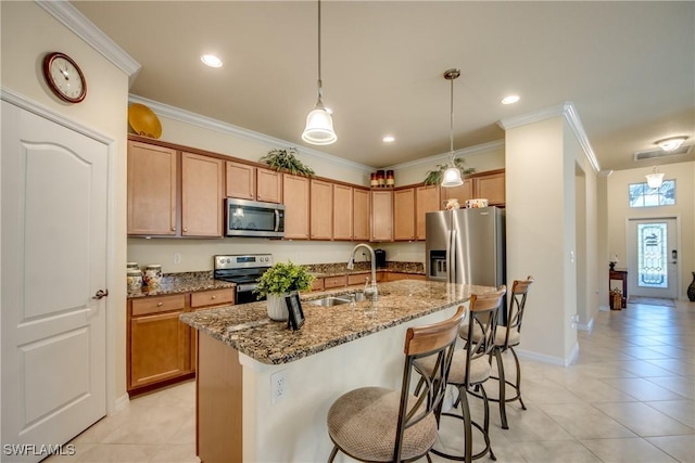 kitchen with stainless steel appliances, crown molding, a sink, and an island with sink