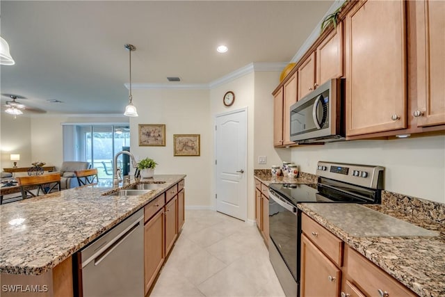 kitchen with stainless steel appliances, a sink, ornamental molding, an island with sink, and decorative light fixtures