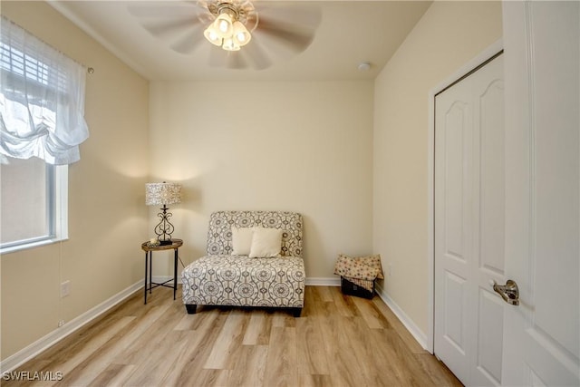 sitting room featuring light wood finished floors, plenty of natural light, and baseboards