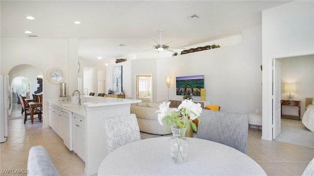 dining room featuring arched walkways, ceiling fan, light tile patterned flooring, and visible vents