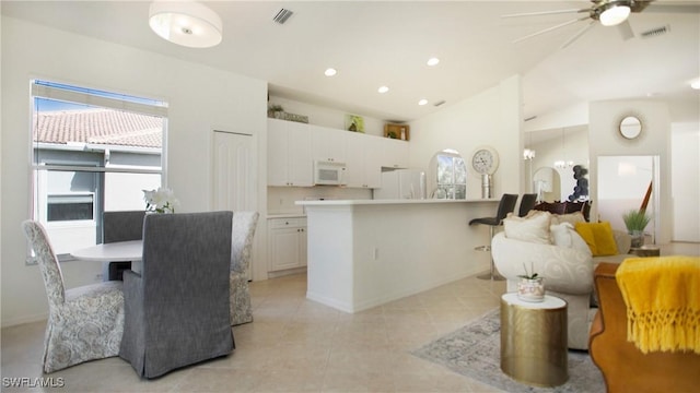 kitchen with light tile patterned floors, light countertops, visible vents, white cabinetry, and white appliances