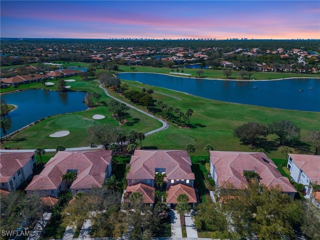 birds eye view of property featuring golf course view, a water view, and a residential view