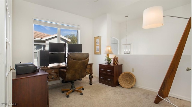 office area featuring light carpet, baseboards, and a notable chandelier