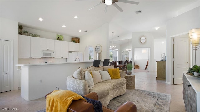 living area with light tile patterned floors, high vaulted ceiling, recessed lighting, ceiling fan with notable chandelier, and visible vents