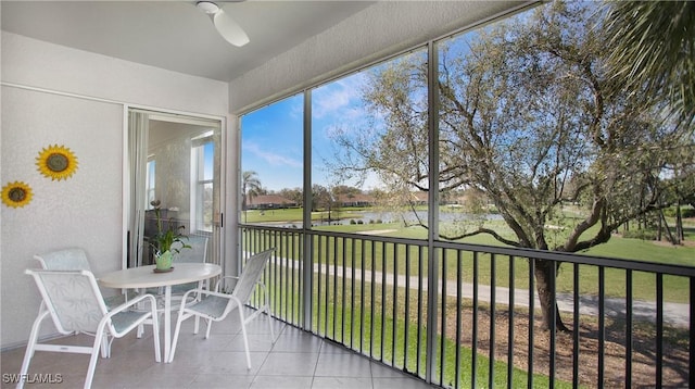 unfurnished sunroom with a water view and a ceiling fan