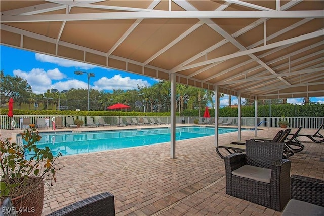 pool with a patio and fence