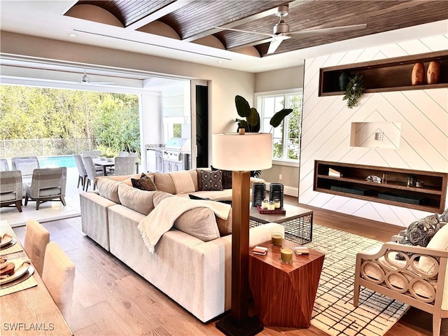 living room featuring hardwood / wood-style floors, ceiling fan, and beam ceiling