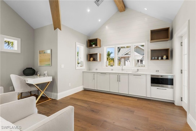 bar featuring oven, visible vents, a wealth of natural light, and wood finished floors