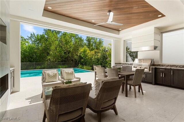 view of patio / terrace featuring area for grilling, outdoor dining space, a ceiling fan, fence, and exterior kitchen