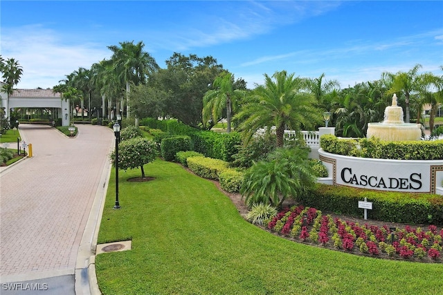 view of community featuring decorative driveway and a lawn