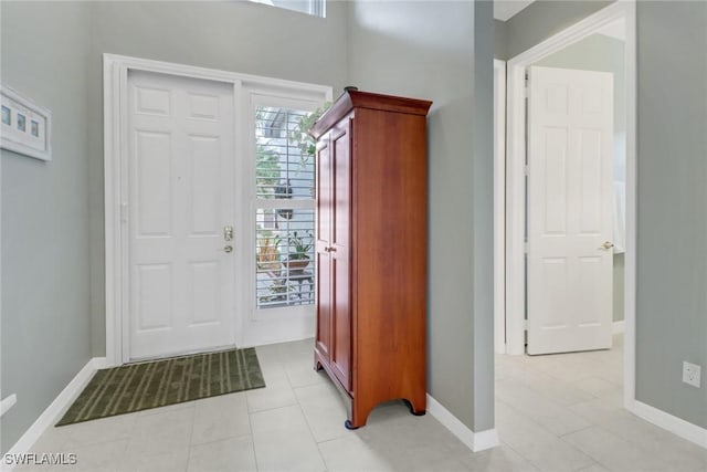 foyer entrance featuring light tile patterned floors and baseboards