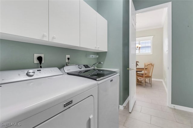 laundry room with crown molding, washing machine and clothes dryer, cabinet space, a sink, and baseboards