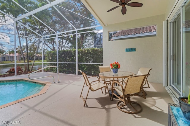 pool with a ceiling fan, a patio area, and glass enclosure