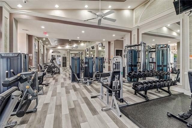 gym featuring a ceiling fan, recessed lighting, light wood-style flooring, and a high ceiling