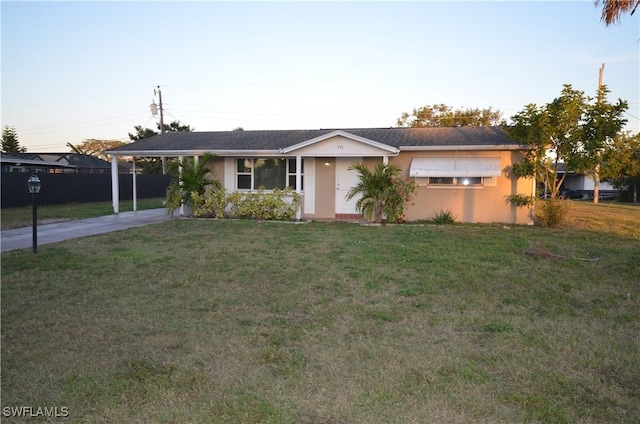 ranch-style house featuring a front yard and a carport