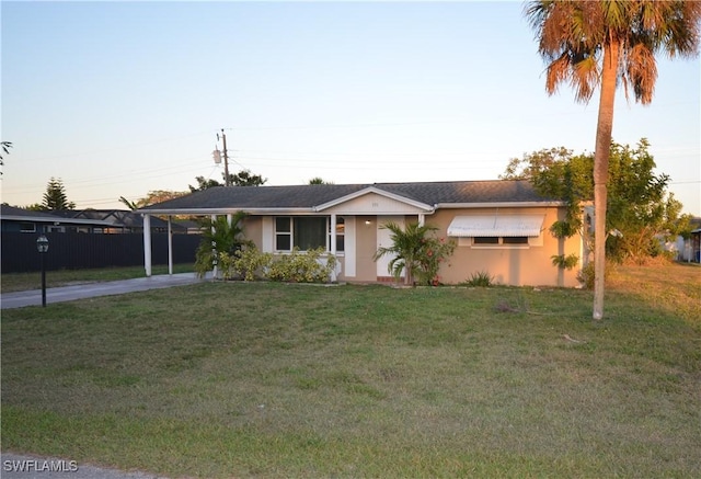 ranch-style house with a lawn and a carport