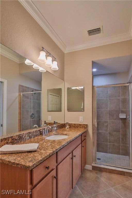 bathroom with crown molding, tile patterned flooring, vanity, and a shower with door