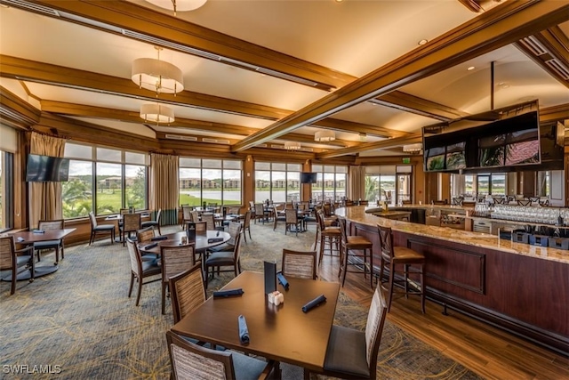 dining room with beamed ceiling and a wealth of natural light