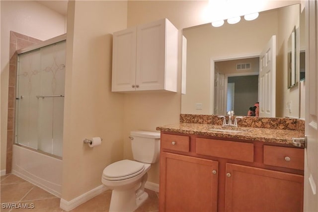 full bathroom featuring vanity, tile patterned flooring, shower / bath combination with glass door, and toilet