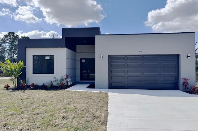 contemporary home with a front lawn and a garage