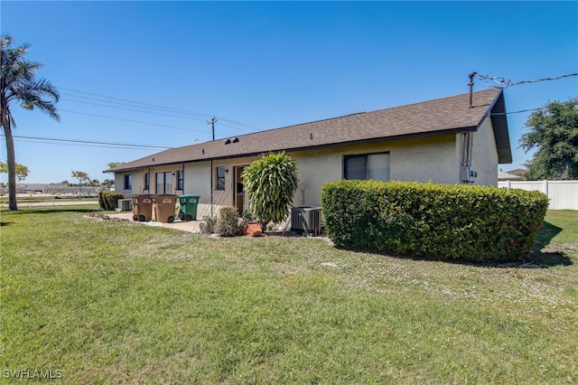 back of house with a yard and central AC unit