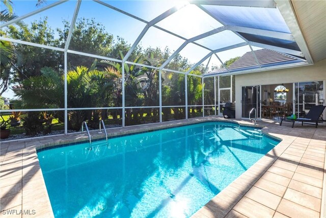 pool with glass enclosure and a patio area