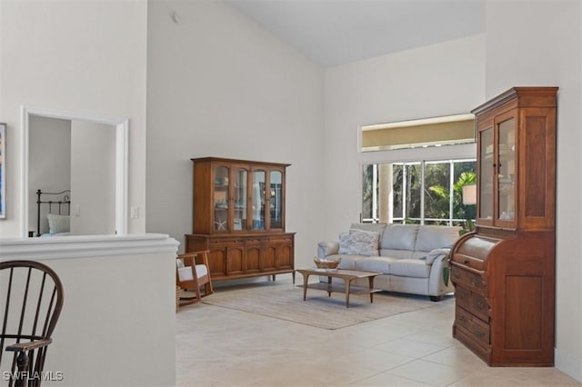 living room with high vaulted ceiling and light tile patterned flooring