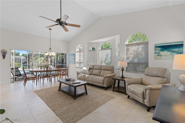 living room with ceiling fan with notable chandelier, high vaulted ceiling, and light tile patterned flooring