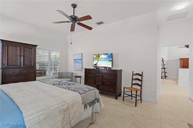 bedroom featuring light tile patterned floors, a ceiling fan, a towering ceiling, visible vents, and baseboards