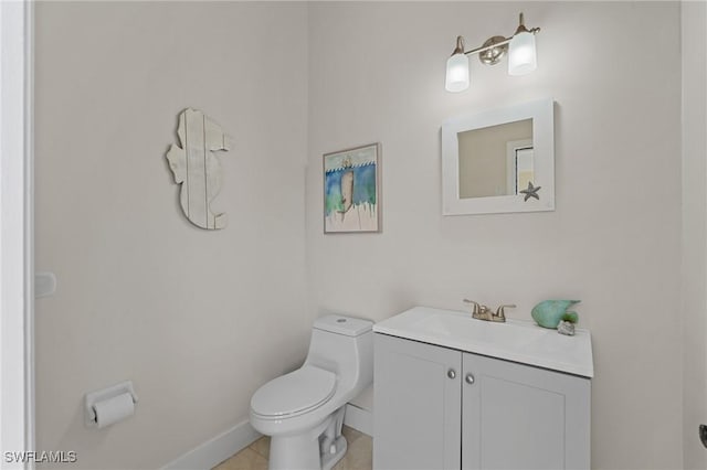 bathroom with tile patterned flooring, vanity, toilet, and baseboards