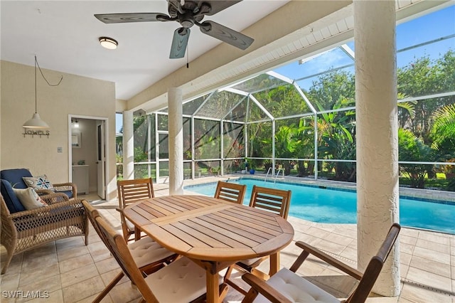 outdoor pool featuring glass enclosure, a ceiling fan, and a patio