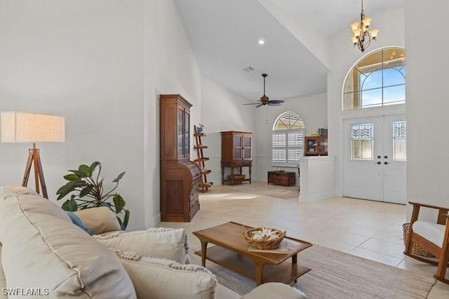 living area with french doors, light tile patterned floors, recessed lighting, a towering ceiling, and ceiling fan with notable chandelier