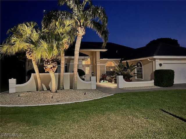 522 SW 51st Ter, Cape Coral, FL 33914 - view of front of house featuring a garage, stucco siding, and a lawn