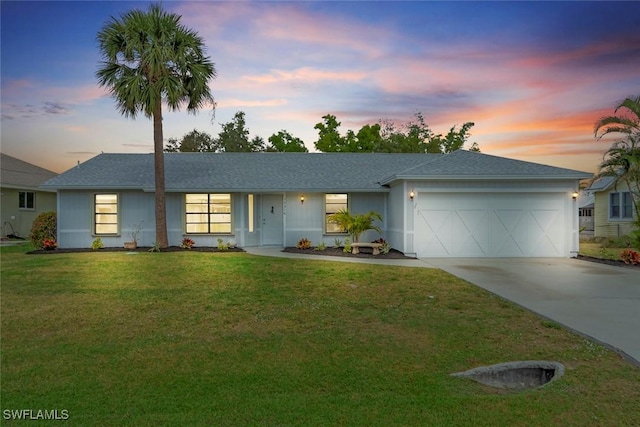 ranch-style home with a garage and a lawn