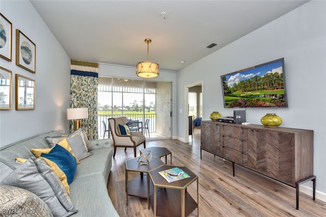 living room with wood finished floors, visible vents, and baseboards