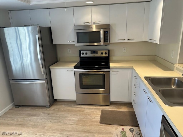 kitchen featuring white cabinetry, light hardwood / wood-style flooring, stainless steel appliances, and sink