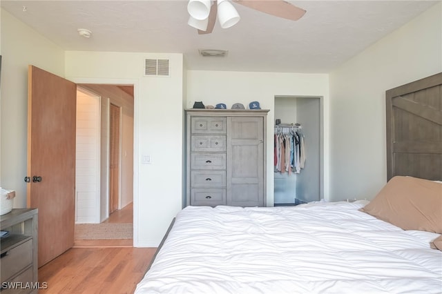 bedroom with light wood-type flooring, a closet, and ceiling fan