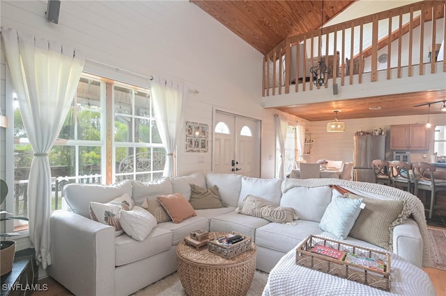 living room featuring high vaulted ceiling and wooden ceiling