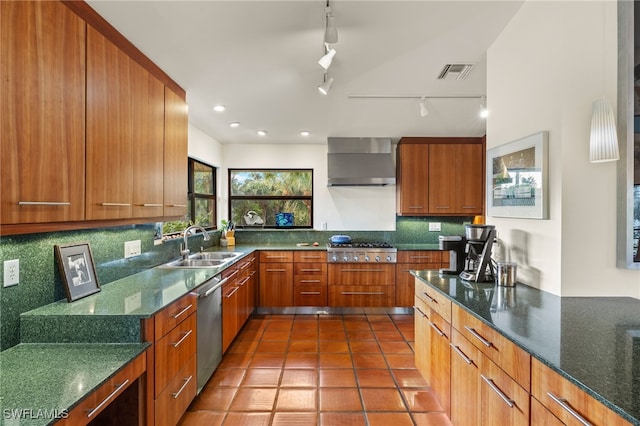 kitchen featuring appliances with stainless steel finishes, tasteful backsplash, wall chimney exhaust hood, dark stone counters, and sink