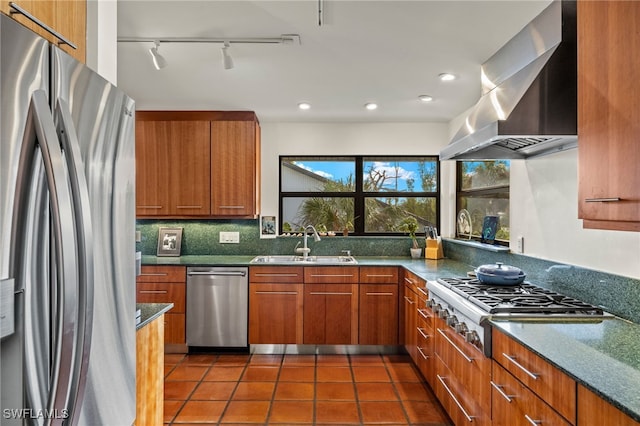 kitchen with dark tile patterned floors, sink, backsplash, appliances with stainless steel finishes, and island range hood