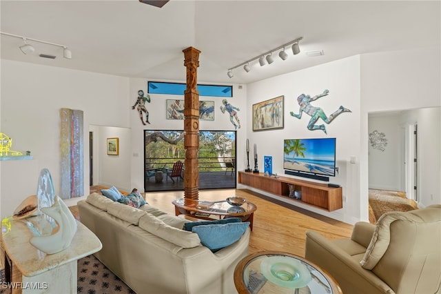 living room featuring ornate columns, light hardwood / wood-style floors, and track lighting