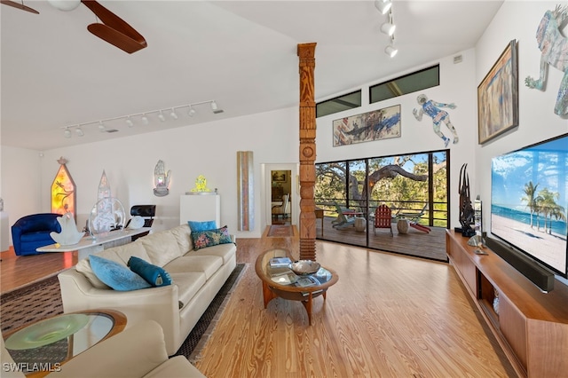 living room with light hardwood / wood-style flooring and a towering ceiling