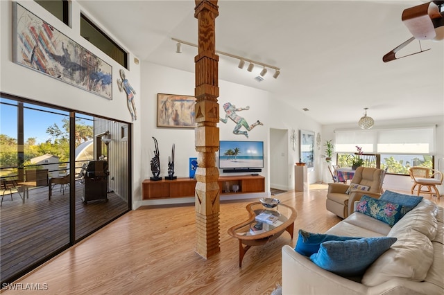 living room with light hardwood / wood-style floors, high vaulted ceiling, ceiling fan, and track lighting