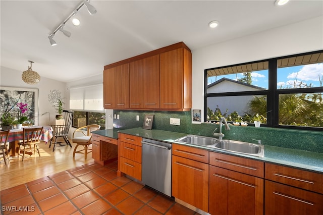 kitchen featuring a healthy amount of sunlight, sink, backsplash, and stainless steel dishwasher