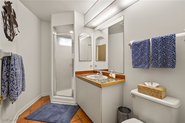 bathroom featuring tile patterned flooring, vanity, toilet, and walk in shower