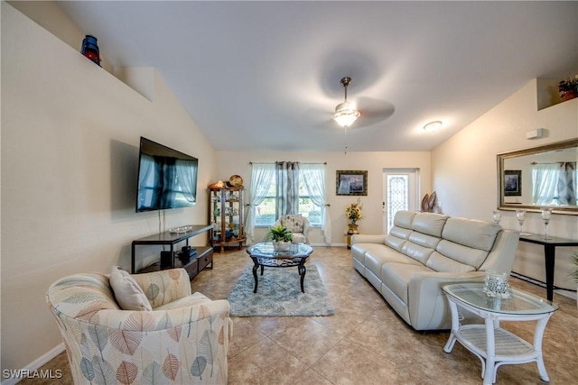 living area with light tile patterned floors, ceiling fan, baseboards, and vaulted ceiling