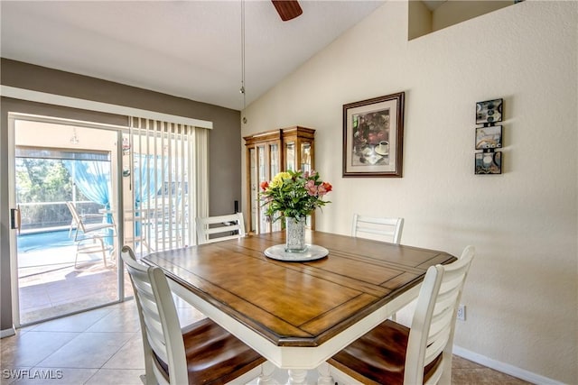 dining space featuring light tile patterned floors, ceiling fan, baseboards, and vaulted ceiling