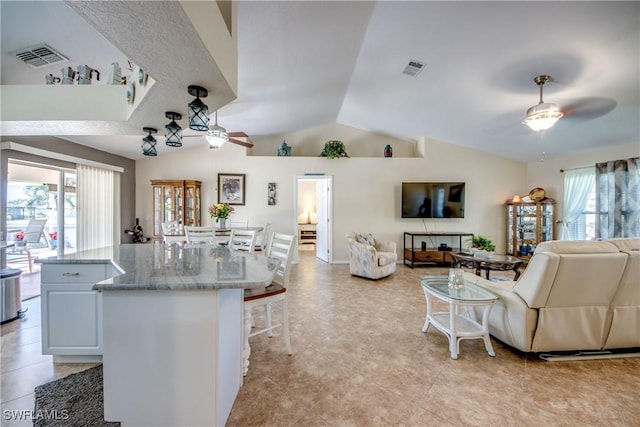 interior space featuring plenty of natural light, open floor plan, visible vents, and ceiling fan