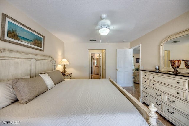 bedroom with connected bathroom, visible vents, and a ceiling fan