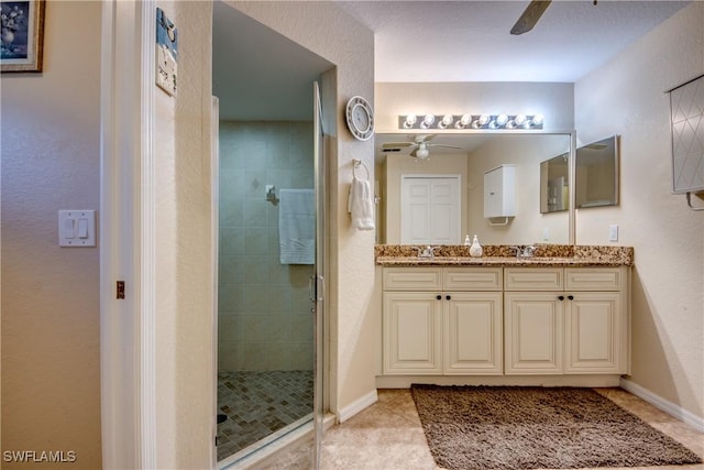 full bath with double vanity, a stall shower, a ceiling fan, and tile patterned floors